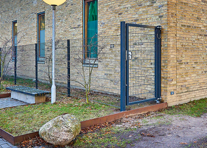 Gitterlåge i antracitgrå og med hanekam på toppen samt panelhegn